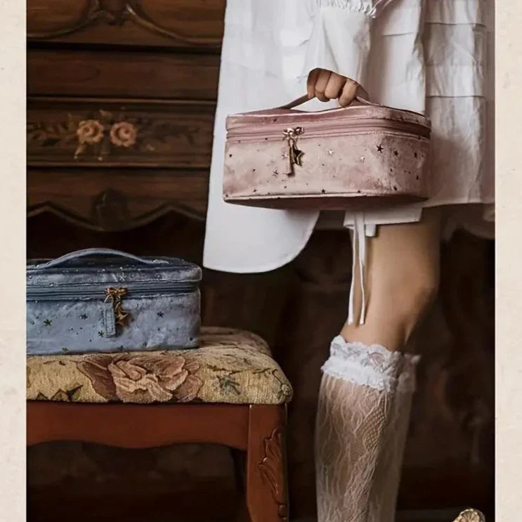 Donna con calze di pizzo bianco tiene una borsa cosmetica rosa, accanto a una borsa blu su sedia vintage. Elegante, retrò, accessori moda.
