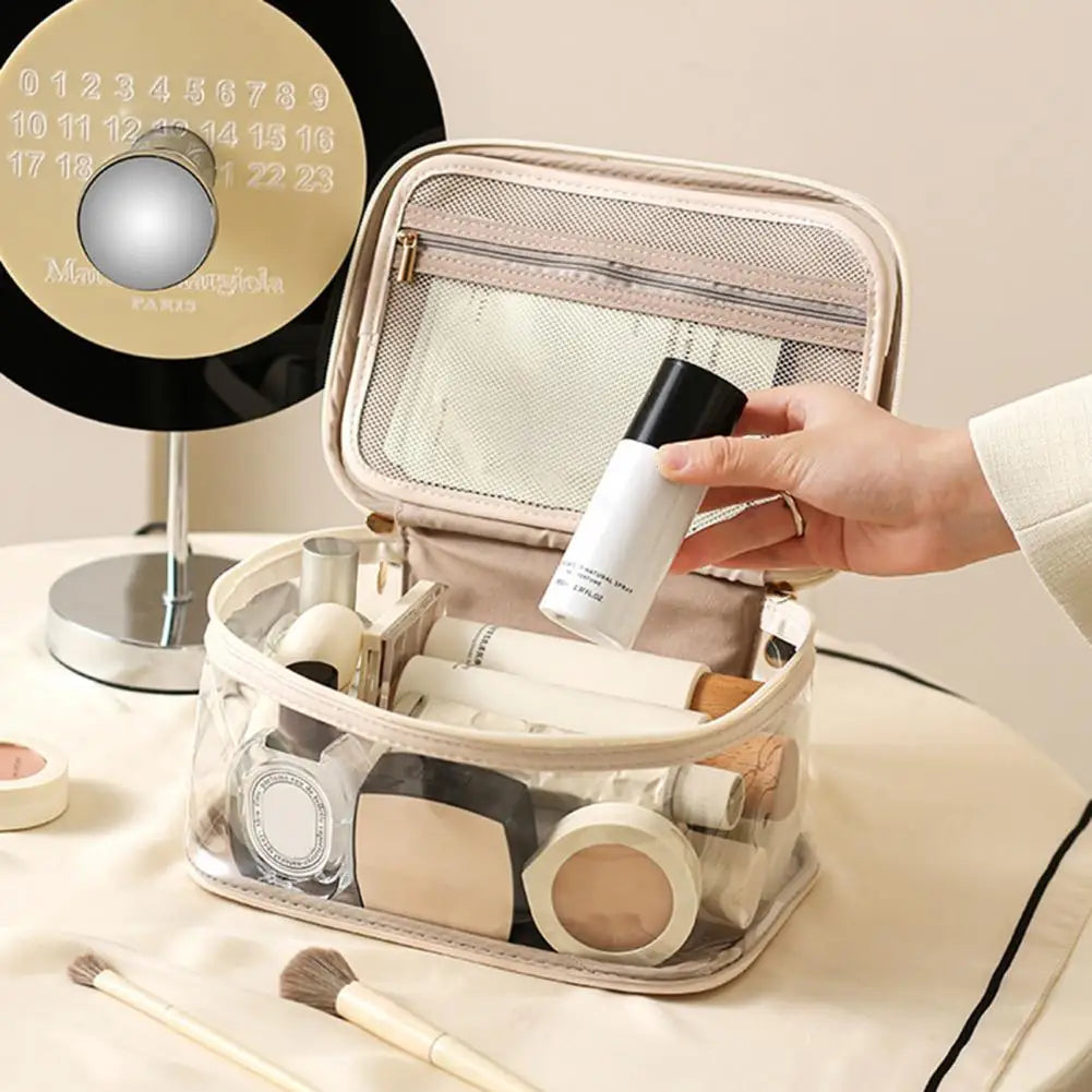 Borsa trasparente per cosmetici con prodotti di bellezza, specchio rotondo e mano femminile. Organizzatore trucco, accessori make-up, beauty case.