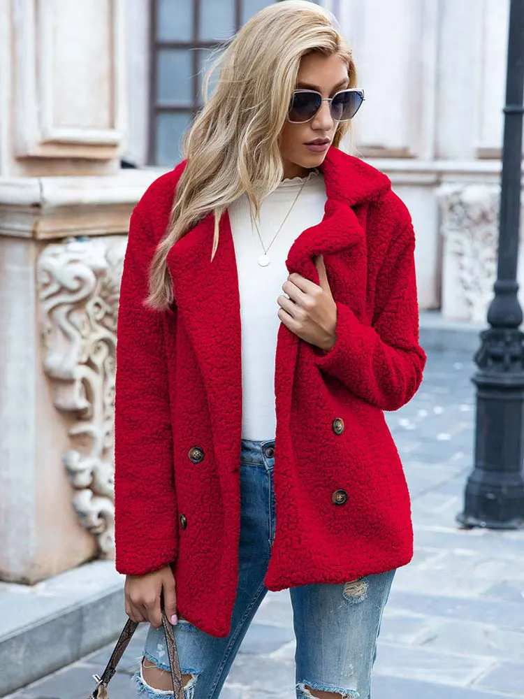 Donna con cappotto rosso in pelliccia sintetica, occhiali da sole, jeans strappati, maglia bianca. Moda autunnale, stile urbano elegante.