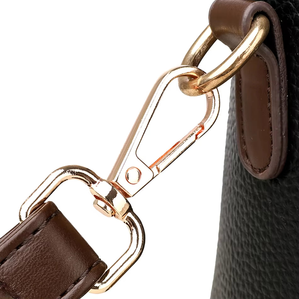 Gancio in metallo dorato su borsa in pelle marrone e nera, dettaglio di alta qualità, accessorio moda elegante, chiusura sicura e resistente.