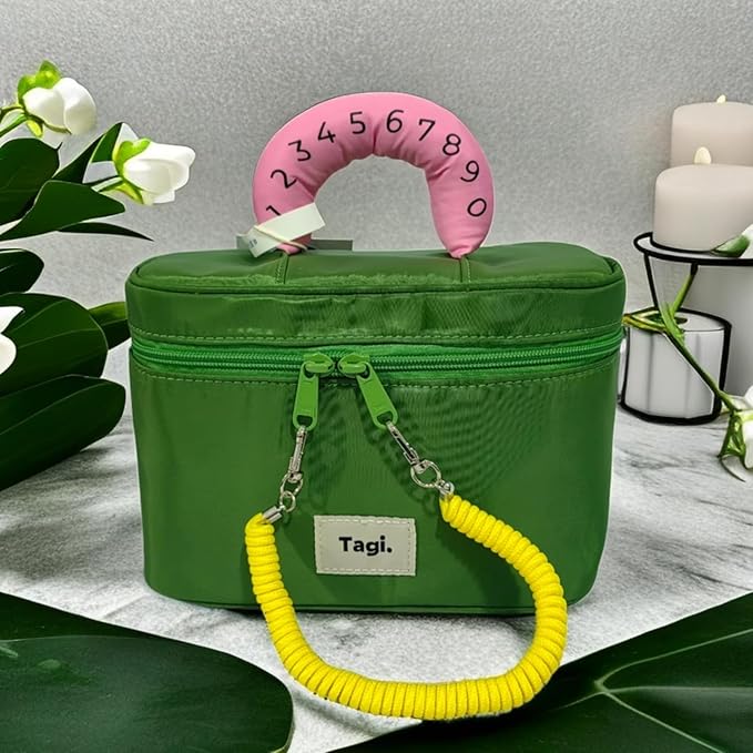 Borsa verde con manico rosa numerato, cerniera doppia e manico giallo. Sfondo con foglie verdi e candele bianche. Accessorio moda elegante.