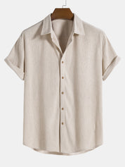 Camicia beige a maniche corte in lino, colletto classico, bottoni frontali, design casual estivo. Ideale per look eleganti e freschi.