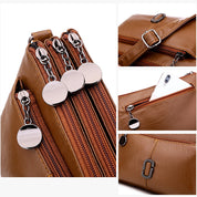 Borsa a tracolla in pelle marrone con tre scomparti, cerniere in metallo, tasca per smartphone e dettagli eleganti. Accessorio moda donna.