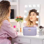 Donna seduta davanti a specchio con luci, borsa cosmetica viola su tavolo da trucco, fiori e pennelli. Accessori bellezza, organizzazione trucco.