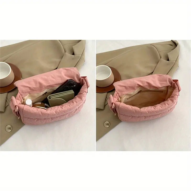 Borsa a tracolla rosa imbottita aperta su cappotto beige, contenente portafoglio, smartphone e cosmetici. Accessorio moda donna elegante e pratico.