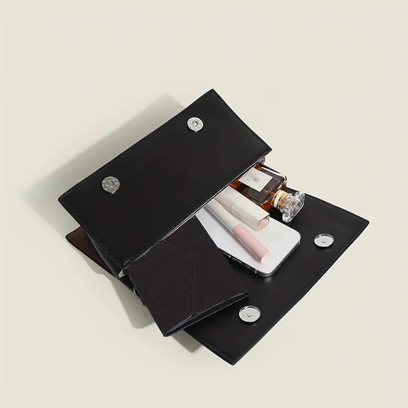 Portafoglio nero in pelle aperto con smartphone, rossetto, profumo e accessori. Design elegante, ideale per moda e accessori donna.