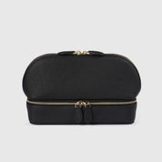 Elegante borsa cosmetica in pelle nera con doppia cerniera dorata, design compatto e moderno, ideale per viaggi e organizzazione trucco.
