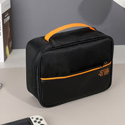 Custodia nera per console di gioco portatile, con manico arancione e tasca frontale con cerniera, su tavolo grigio. Accessorio per Nintendo Switch.