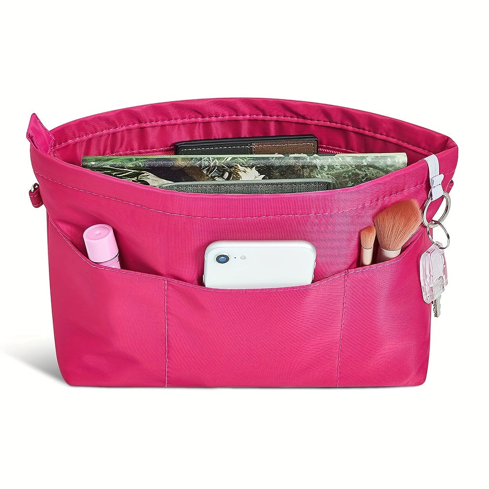 Organizer borsa rosa con tasche multiple, contenente smartphone, trucchi e chiavi. Accessorio pratico per organizzare oggetti personali.