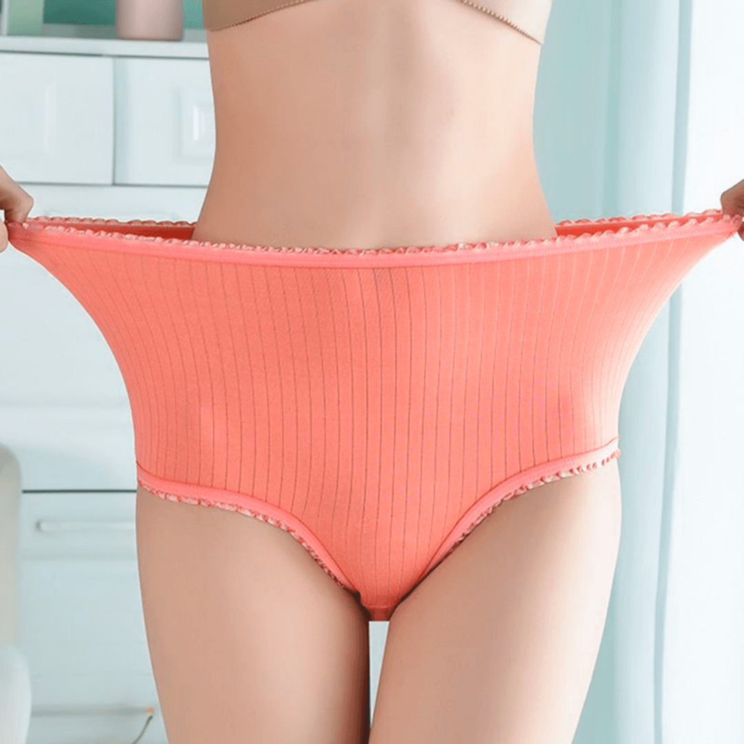 Mutande a vita alta in cotone elasticizzato rosa, design a coste, indossate da una donna. Intimo comodo e traspirante per il massimo comfort.