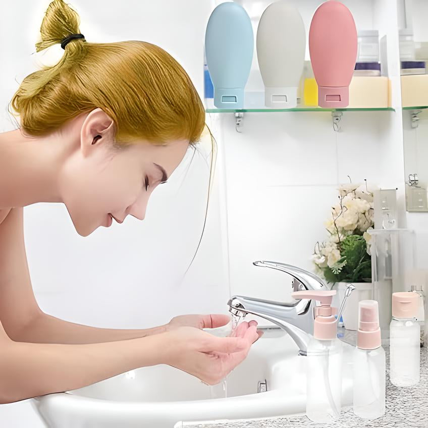 Donna che si lava il viso in bagno moderno, flaconi da viaggio colorati sullo sfondo. Cura della pelle, routine di bellezza, igiene personale.