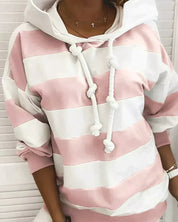 Felpa a righe rosa e bianche con cappuccio e lacci, indossata da una persona. Moda casual, abbigliamento donna, stile autunnale.