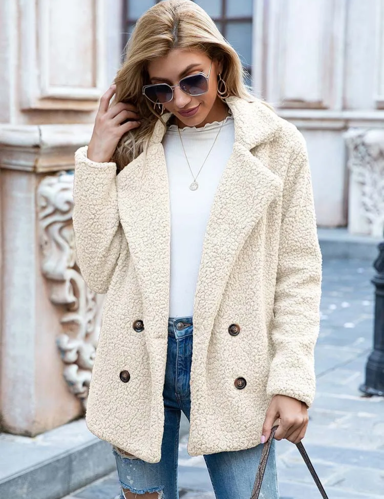 Donna con cappotto in pile beige, occhiali da sole, jeans strappati e maglia bianca. Moda autunnale, abbigliamento casual elegante.