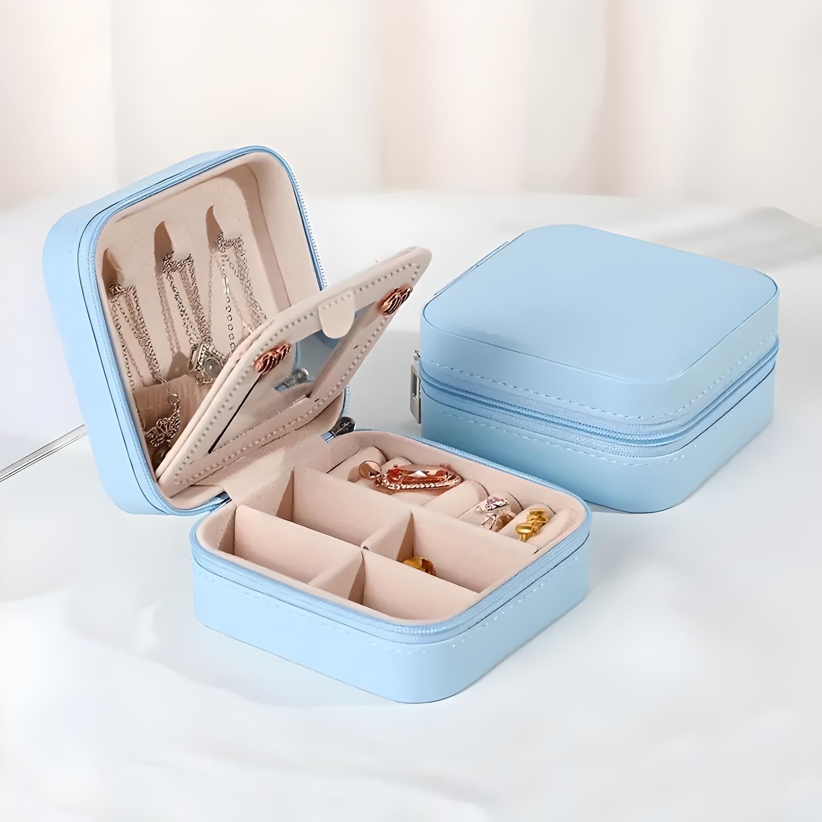 Scatola portagioie da viaggio azzurra con scomparti, ideale per organizzare collane, anelli e orecchini. Design compatto e elegante.