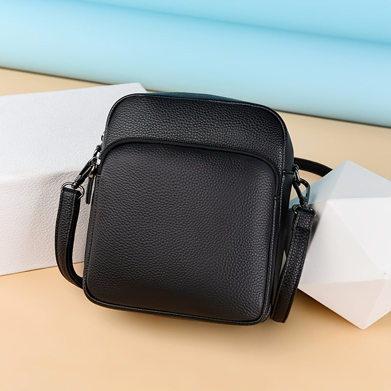 Borsa a tracolla in pelle nera su sfondo colorato, design elegante e moderno, ideale per uomo e donna. Accessorio moda versatile e di tendenza.