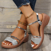 Sandali donna con zeppa, cinturini argento lucido, suola marrone, design elegante e moderno, perfetti per l'estate e occasioni casual.