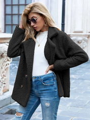 Donna con cappotto in pile nero, occhiali da sole, maglia bianca e jeans strappati. Moda autunnale, abbigliamento casual elegante.