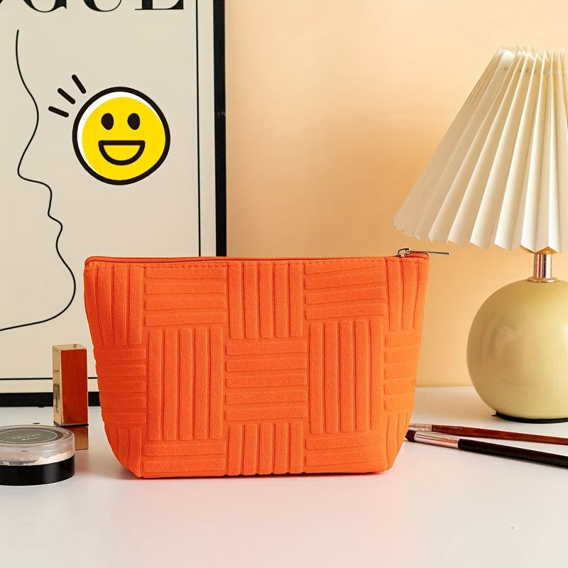Borsa cosmetica arancione su tavolo bianco, lampada moderna e poster artistico. Design trapuntato, accessorio moda, organizzazione trucco.