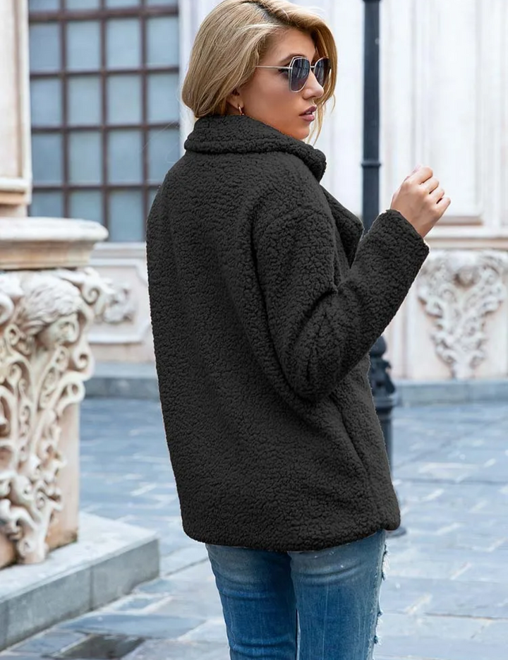 Giacca in pile nero donna, stile casual, indossata all'aperto. Moda autunno inverno, tessuto caldo e morbido, ideale per look urbano.