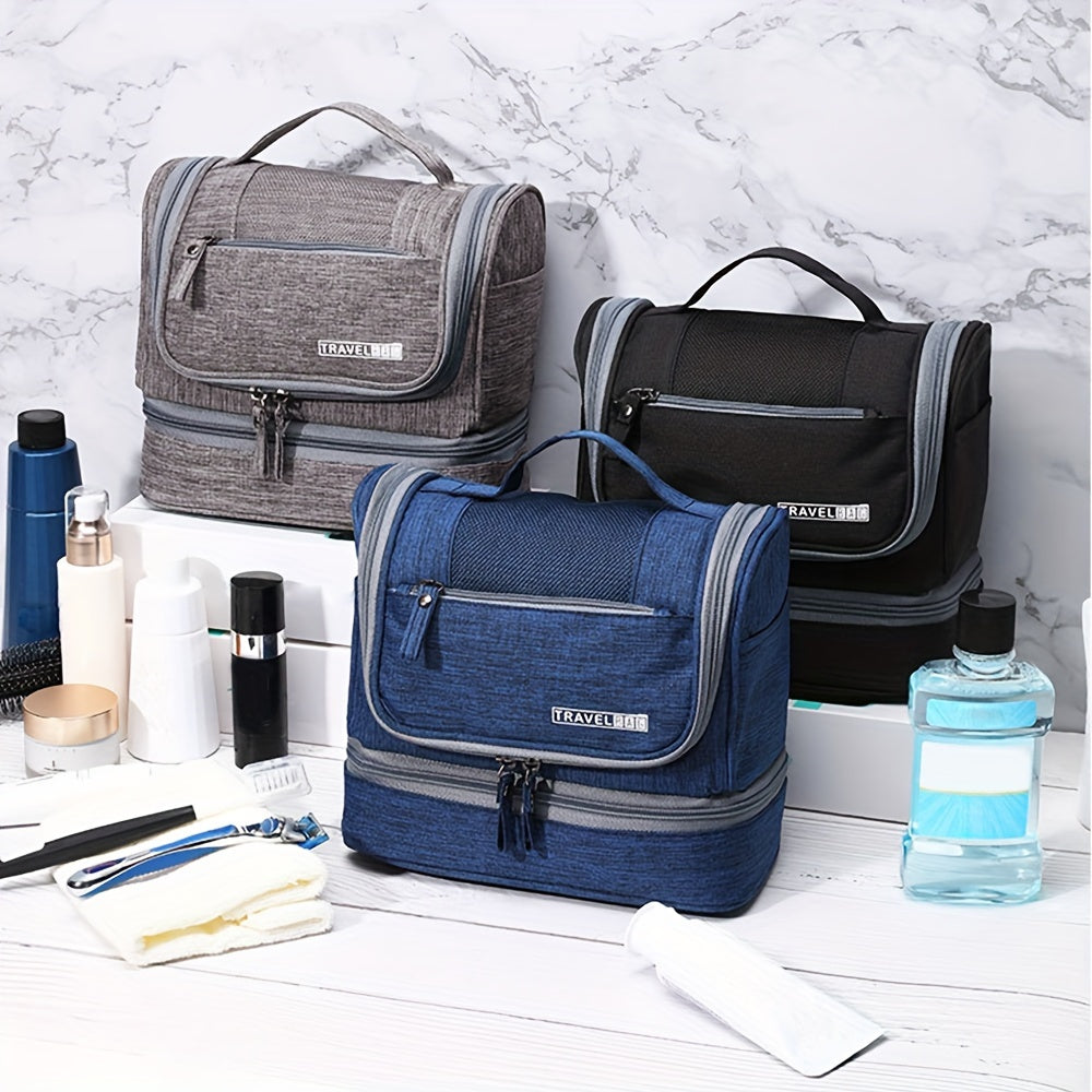Tre beauty case da viaggio in tessuto, colori grigio, nero e blu, con zip e manico, su sfondo marmo. Accessori da bagno inclusi.