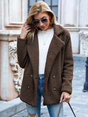 Donna con cappotto marrone in lana bouclé, occhiali da sole, maglia bianca e jeans strappati. Moda autunnale, abbigliamento casual elegante.