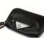 Borsa da viaggio in pelle nera con cerniera aperta, mostra uno smartphone all'interno. Accessorio elegante e funzionale per uomo e donna.