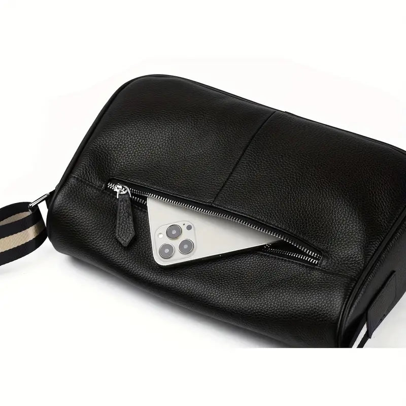 Borsa da viaggio in pelle nera con cerniera aperta, mostra uno smartphone all'interno. Accessorio elegante e funzionale per uomo e donna.