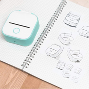 Stampante termica portatile su quaderno a spirale con schizzi. Design compatto, ideale per etichette e note. Tecnologia di stampa senza inchiostro.