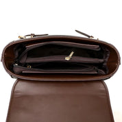 Interno di borsa a tracolla in pelle marrone, con scomparti multipli e cerniere dorate. Design elegante e funzionale per moda donna.