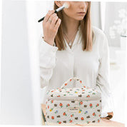 Donna applica trucco con pennello, accanto a beauty case floreale. Moda, accessori, trucco, bellezza, borsa cosmetica, routine mattutina.