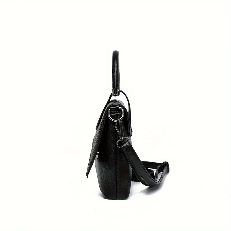 Borsa a tracolla nera in pelle, vista laterale, con manico superiore e tracolla regolabile. Design elegante e moderno per donna.