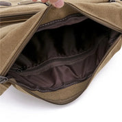 Borsa a tracolla in tela marrone aperta, con scomparto interno foderato e tasca con cerniera, ideale per uomo e donna, moda casual e resistente.