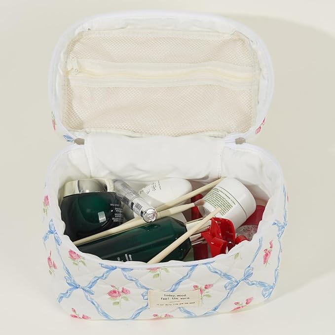 Beauty case floreale aperto con prodotti cosmetici, tra cui creme e flaconi. Design elegante, ideale per organizzare articoli da toeletta.