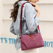 Donna con borsa a tracolla in tessuto rosa, indossa camicia di jeans. Accessorio moda casual, ideale per shopping e uscite quotidiane.
