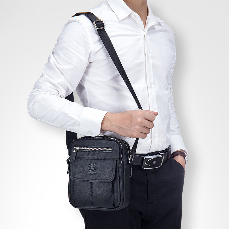 Uomo con camicia bianca indossa borsa a tracolla in pelle nera, elegante e pratica, ideale per lavoro e viaggio. Accessorio moda maschile.