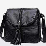 Borsa a tracolla in pelle nera con zip centrale e nappine decorative, design elegante e moderno, ideale per moda femminile e uso quotidiano.