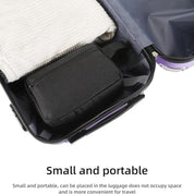 Valigia aperta con borsa nera compatta e asciugamano bianco, ideale per viaggi. Design piccolo e portatile, perfetto per ottimizzare lo spazio.