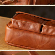 Borsa in pelle marrone su tavolo di legno, dettagli cuciture e tasche. Accessorio moda elegante, artigianato di qualità, stile classico.