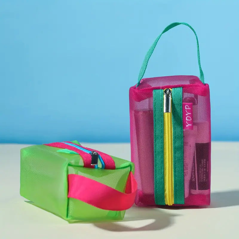 Due astucci colorati in tessuto trasparente, uno verde e uno rosa, con cerniere multicolore e manici, ideali per cosmetici o articoli da viaggio.