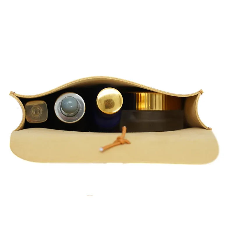Borsa cosmetica beige aperta con flaconi di profumo e crema. Accessori bellezza, organizer viaggio, custodia trucco elegante.