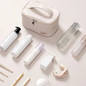 Set di cosmetici e accessori da viaggio su sfondo chiaro, include flaconi, contenitori e borsa organizer. Ideale per beauty routine e viaggi.