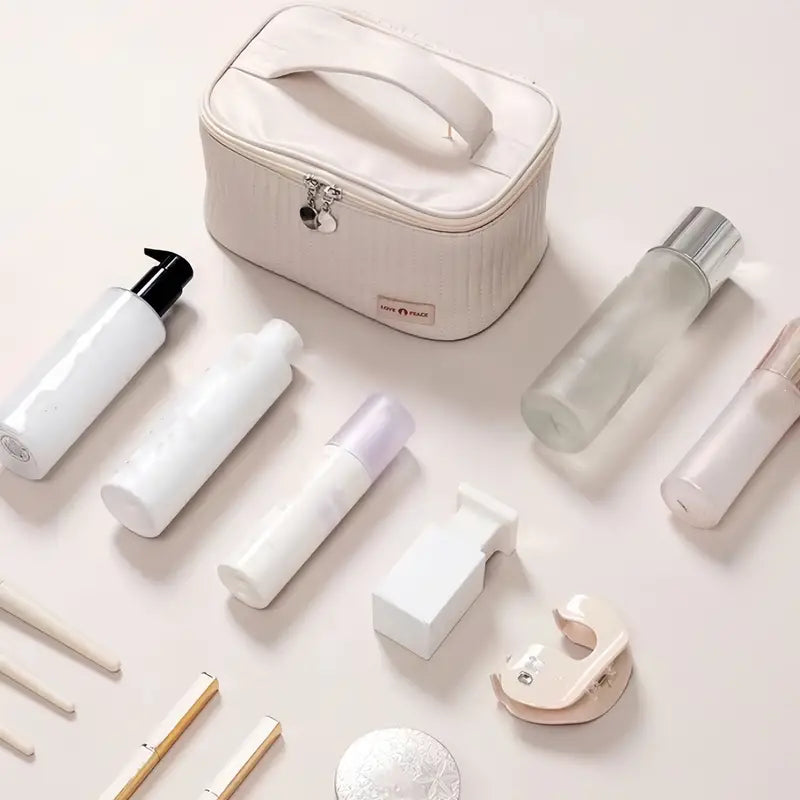 Set di cosmetici e accessori da viaggio su sfondo chiaro, include flaconi, contenitori e borsa organizer. Ideale per beauty routine e viaggi.