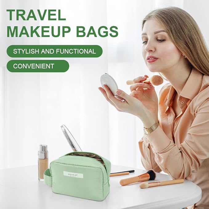 Donna che applica trucco con specchio, accanto a borsa trucco da viaggio verde su tavolo bianco. Include pennelli e fondotinta. Elegante e funzionale.
