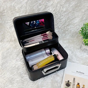 Astuccio nero per trucco con specchio, pennelli, flaconi cosmetici su sfondo di pelliccia bianca. Organizzatore beauty case elegante e funzionale.