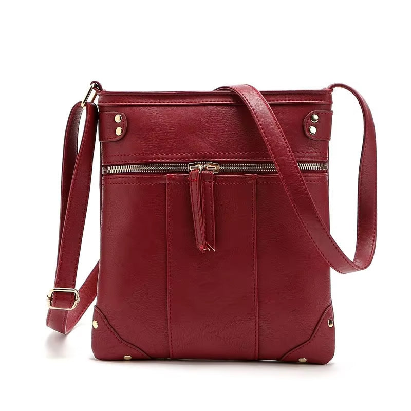 Borsa a tracolla in pelle rossa con cerniera frontale, design elegante e moderno, ideale per donna. Accessorio moda versatile e di tendenza.