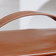 Manico di borsa in pelle marrone chiaro, dettaglio elegante e moderno, accessorio moda di alta qualità, design minimalista.