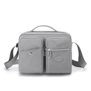 Borsa a tracolla grigia in pelle sintetica con tasche multiple e cerniere, design elegante e funzionale, ideale per uomo e donna.