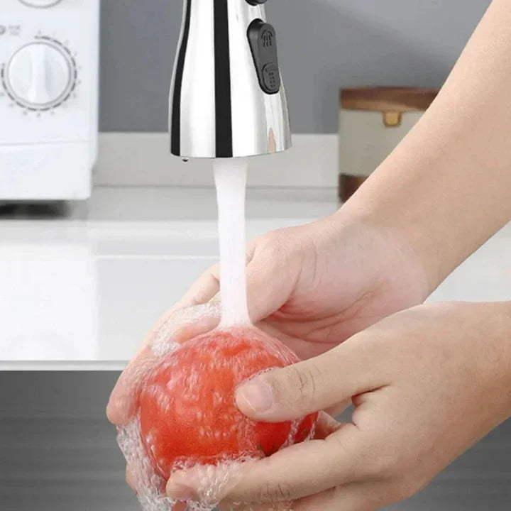 Mani lavano pomodoro sotto rubinetto cucina cromato, acqua corrente. Cucina moderna, igiene alimentare, preparazione cibo fresco.