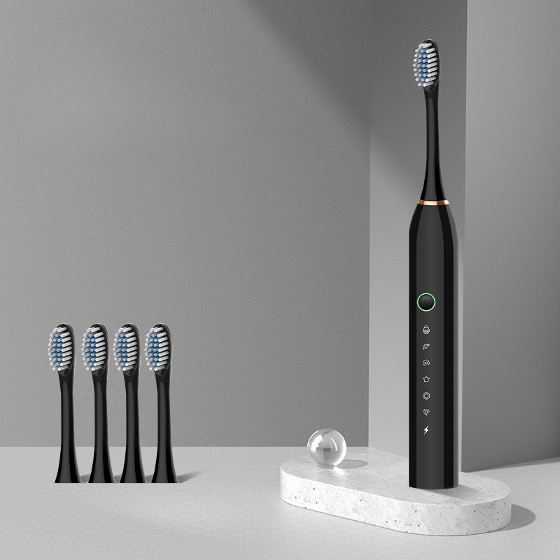 Spazzolino elettrico nero con cinque testine di ricambio su supporto in marmo, design moderno, set igiene orale avanzato.