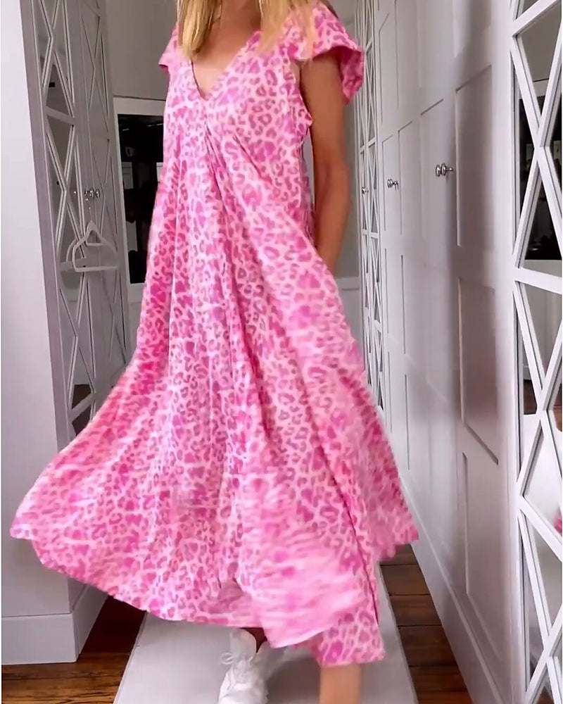 Abito lungo rosa con stampa leopardata, maniche corte, scollo a V, indossato da donna in corridoio. Moda estiva, abbigliamento casual elegante.